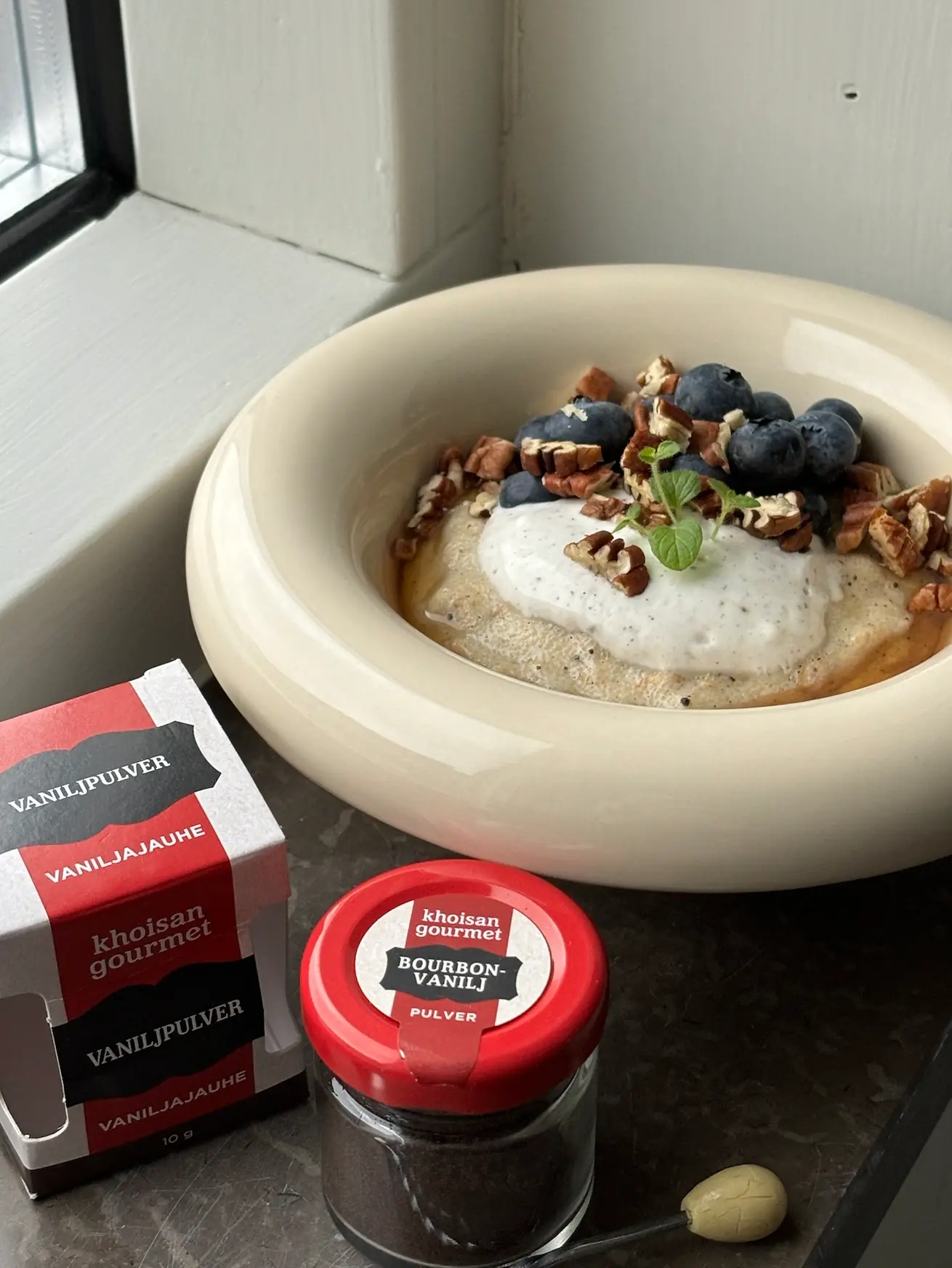 Vaniljfrukostgröt toppad med grekisk yoghurt, blåbär & pekannötter